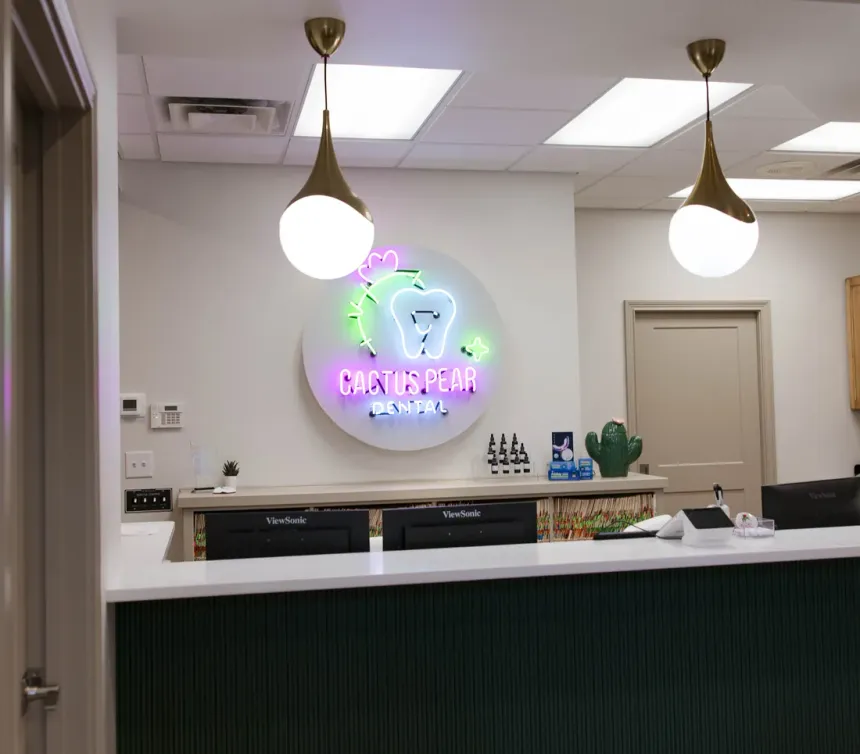 The Cactus Pear Dental reception desk, with the practice logo on the wall behind it