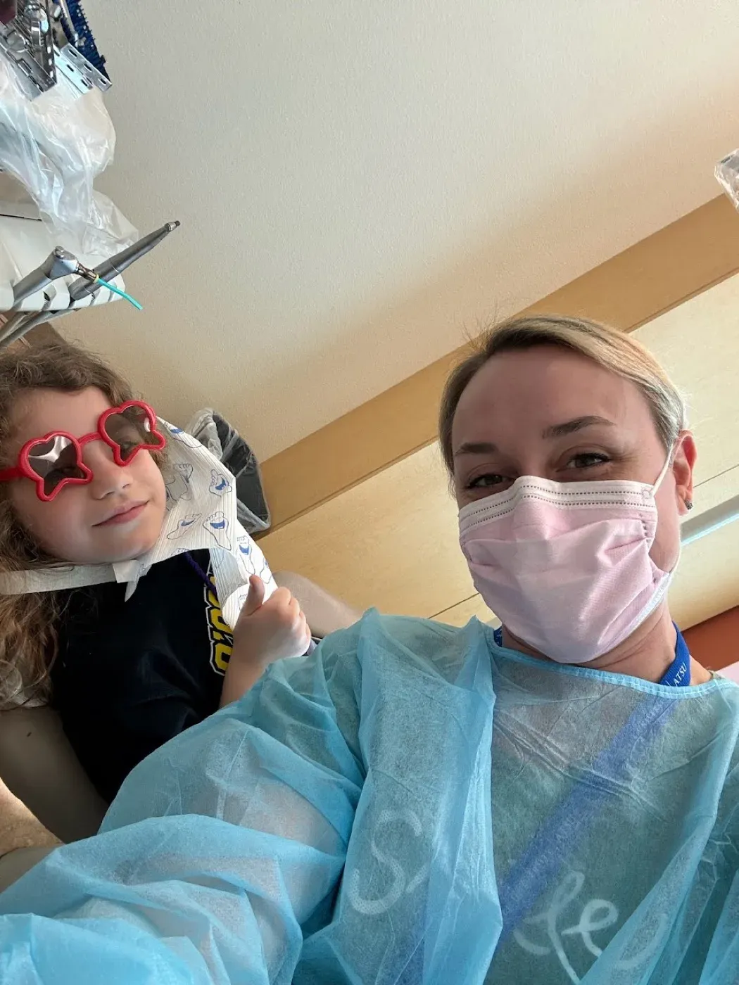 Dr. Oberlander with a young patient wearing star-shaped sunglasses