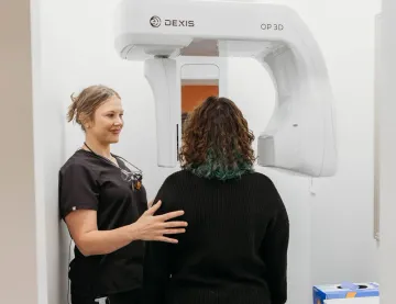A patient standing in the panoramic X-ray unit